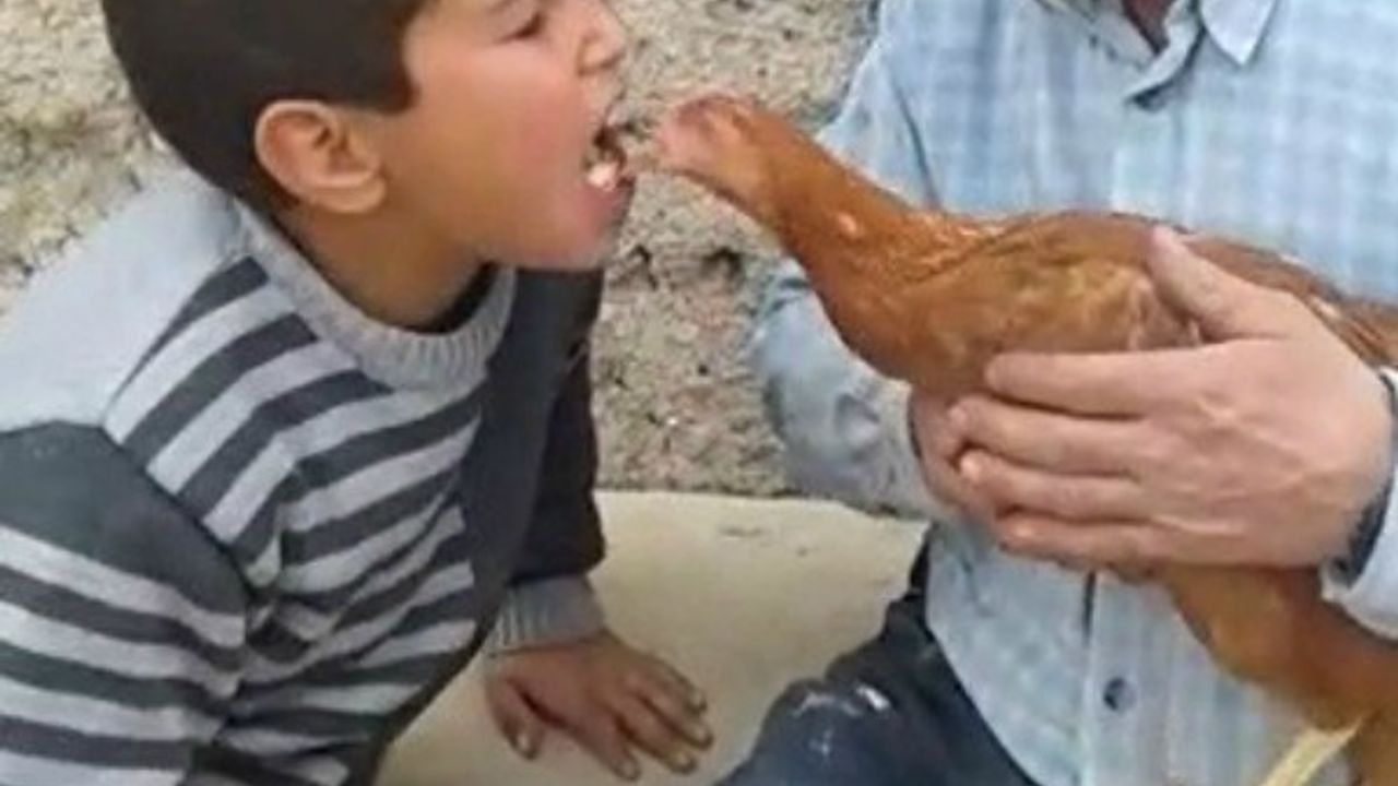 Ağzındaki yem ile tavuğu besleyen küçük çocuğun görüntüsü büyük beğeni kazandı 