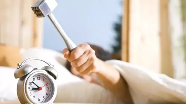 6. Alarm Tuzağından Kaçının
Çoğumuzun sabahları karşılaştığı en büyük engel, alarmı ertelemek veya bilinçsizce kapatıp uyumaya devam etmek. Bu alışkanlığı kırmak için alarmınızı yataktan uzakta bir yere koyun. Alarm çaldığında kapatmak için yataktan kalkmanız gerekecek ve bu hareket, uyku halinden kurtulmanızı sağlar.