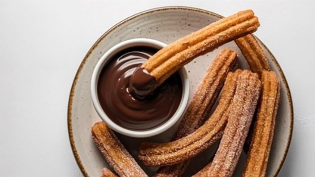 Churros (İspanya)

İspanya’nın sokak lezzeti churros, un, su ve tuzla yapılan hamurun kızartılmasıyla hazırlanır. Şeker ve tarçına bulanır, sıcak çikolata veya karamel sosla yenir. İspanyol çobanların dağlarda kolayca pişirdiği bu tatlı, Latin Amerika’da da oldukça popülerdir.