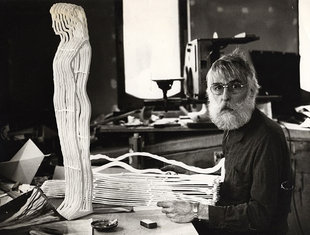 İlhan Koman (1921-1986)
Modern heykel sanatının Türkiye’deki öncülerinden İlhan Koman, İstanbul ve Paris’teki eğitimleriyle soyut formlara dayalı yenilikçi bir anlayış geliştirdi. Eserlerinde materyal ve formu cesurca kullanan Koman, Sonsuzluk, Hommage à Leonardo da Vinci ve Otokon gibi heykelleriyle uluslararası çapta tanındı. Soyut sanatın Türkiye’de benimsenmesine katkı sağlayan Koman, modern Türk heykelciliğine evrensel bir bakış açısı getirdi.