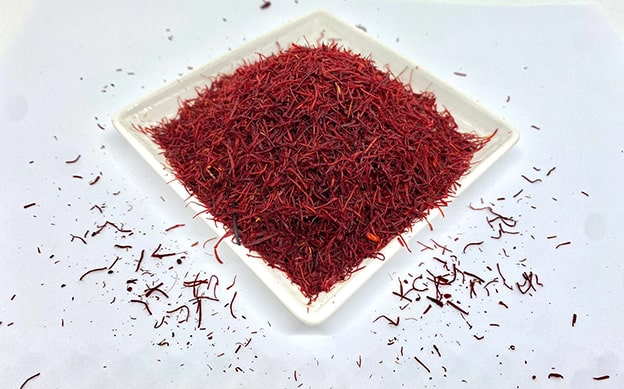 İran Safranı
Güneybatı Asya kökenli İran safranı, keskin tadı ve yemeklere kattığı canlı sarı rengiyle dünyaca ünlüdür. “Crocus sativus” bitkisinin çiçeklerinden elde edilen bu baharat, bir kilogram üretmek için 150.000-200.000 çiçeğin elle toplanmasını gerektirir. Çiçeklerin belirli bir dönemde açması ve hızlı hasat zorunluluğu, safranın nadirliğini artırır. Bu zahmetli süreç, safranı dünyanın en pahalı baharatlarından biri yapar.