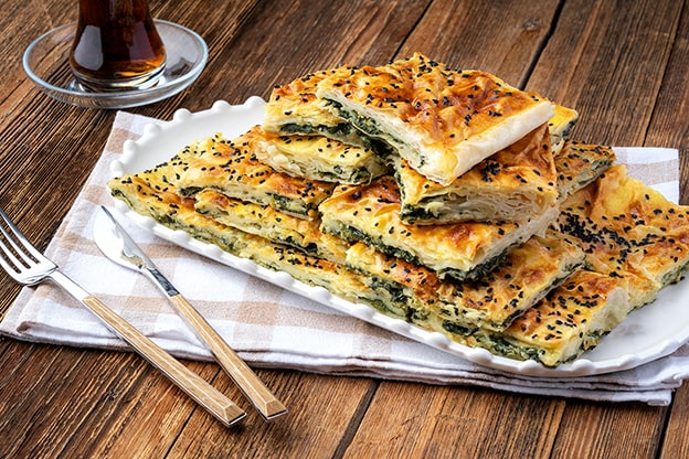 Ispanaklı Börek / Spanakopita
Ispanak ve hamurun birleşimi, Türk mutfağında ıspanaklı börek, Yunan mutfağında ise “spanakopita” olarak hayat buluyor. 