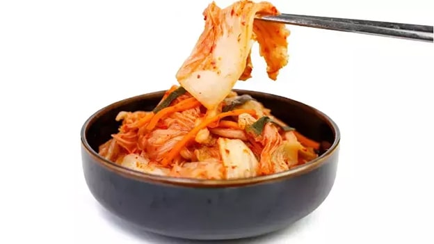 Kimchi Turşusu (Kore Turşusu)
Kore mutfağının ikonik lezzeti kimchi, fermente sebzelerden yapılan bir turşu türü. Lahana ve baharatlarla hazırlanan bu probiyotik deposu, sağlıklı beslenme trendlerinin gözdesi. Acı, ekşi ve umami tatların harmanı olan kimchi, hem yemeklere eşlik ediyor hem de bağışıklığı güçlendiriyor.