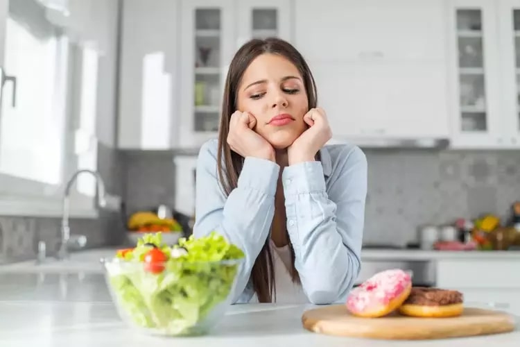 OMAD Diyetinin Temel Prensipleri

OMAD diyeti, 24 saatte 23 saat aç kalıp, 1 saatlik bir zaman diliminde beslenmeyi içerir. Bu süre boyunca sadece su, şekersiz çay veya kahve gibi kalorisiz içecekler tüketilir; kalorili yiyecek ve içecekler yalnızca belirlenen öğünle alınır. Diyetin amacı, uzun açlık dönemleriyle insülin seviyelerini düşürerek vücudun yağ yakımını artırmasıdır. Bu sayede kilo verme ve yağ kaybı desteklenir. Öğünün besin değeri yüksek, protein, sağlıklı yağlar, lifli sebzeler ve kompleks karbonhidratlar içermesi önemlidir. OMAD, disiplinli bir yaklaşım gerektirir ve metabolizma ile yaşam tarzına göre farklı sonuçlar doğurabilir.
