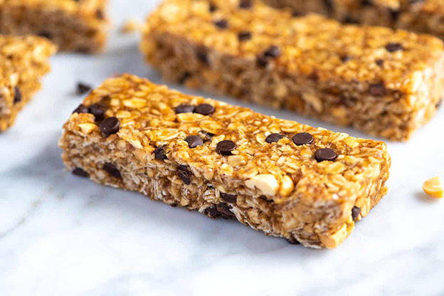 Granola Bar
Granola barlar, kıtır kıtır dokusu ve sağlıklı imajıyla diyetlerin gözdesi. Ancak bir adet granola bar, yaklaşık 480 kaloriyle iki küçük draje paketine denk gelebiliyor. Sağlıklı atıştırmalık olarak görülen bu barlar, abartıldığında kalori yüküyle şaşırtıyor. Granola bar tüketirken porsiyon kontrolüne dikkat etmek, diyet hedeflerinizi korumanıza yardımcı olur.