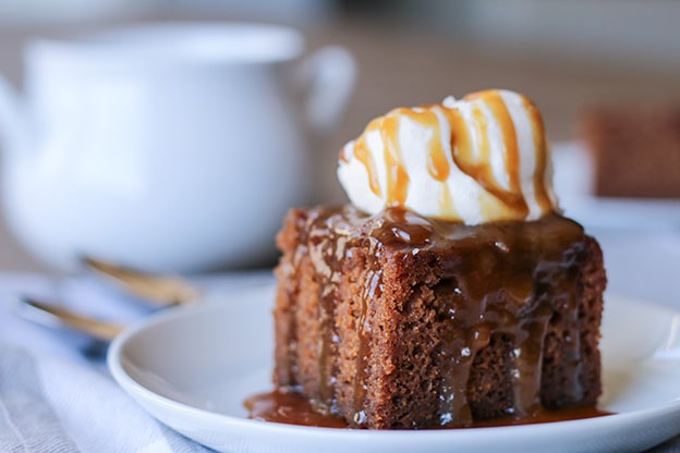Sticky Toffee Pudding (İngiltere)

Hurma ve karamel sosla yapılan bu İngiliz tatlısı, yumuşak kekiyle dikkat çeker. II. Dünya Savaşı’nda tatlandırıcı kıtlığı nedeniyle hurma kullanılarak geliştirildiği söylenir. Sıcak servis edilir, genellikle krema veya vanilyalı dondurmayla sunulur.