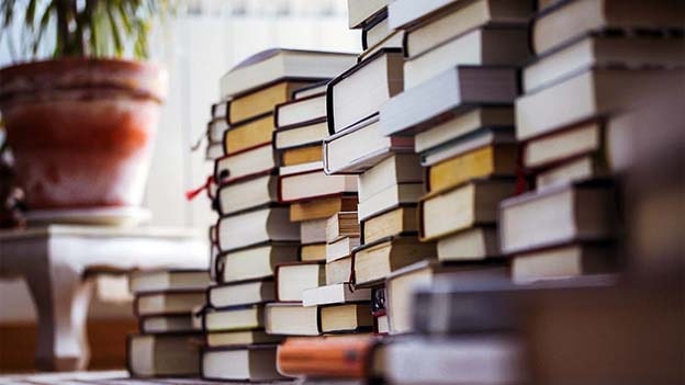 Tsundoku mu, Bibliomani mi?
Tsundoku, sıkça bibliomani ile karıştırılıyor, ancak bu iki durum arasında önemli farklar var. Bibliomanide, kişi kitapları sadece “sahip olma” arzusuyla toplar, okuma niyeti yoktur. Kitabı satın aldığı anda tatmin olur ve suçluluk hissetmez. Tsundoku’da ise temel motivasyon, kitapları okumaktır. Ancak, okunmamış kitap yığınları biriktikçe kişi suçluluk duyar. Bu suçluluk, ironik bir şekilde, yeni kitaplar alarak rahatlamaya çalışma döngüsünü tetikleyebilir. Tsundoku’nun sonucunda ortaya çıkan kütüphane hem bir gurur kaynağı hem de bir duygusal yük haline gelir.