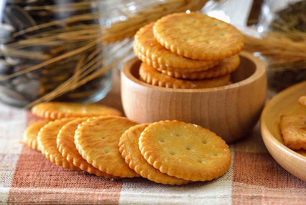 Tuzlu Kraker ve Atıştırmalıklar
Tuzlu krakerler veya cips gibi atıştırmalıklar, tuzlu olmalarına rağmen basit karbonhidratlar içerir. Bu tür gıdalar, iştahı bastırmak yerine kısa sürede açlık hissinin geri gelmesine neden olur. Daha sağlıklı bir alternatif olarak, çiğ kuruyemişler gibi besleyici atıştırmalıklar tercih edilebilir.