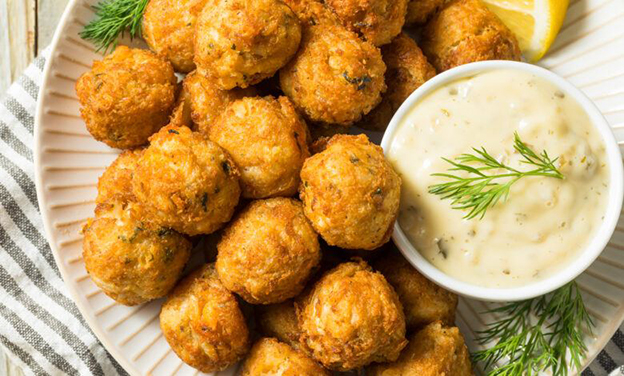 2. Yengeç Köftesi (Crab Cake)
Son yıllarda popülerleşen bu eşleşme, özellikle çıtır dış katmanı ve tatlımsı yengeç etiyle dikkat çeker. Bu lezzet, özellikle orta gövdeli beyaz şaraplarla harika bir uyum içindedir. Ayrıca köpüklü şaraplarla da oldukça şık bir lezzet yaratabilirsiniz.