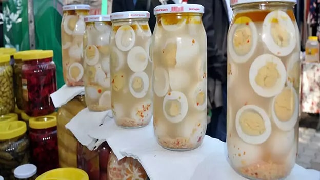Yumurta Turşusu
Yumurta turşusu, belki de listedeki en şaşırtıcı lezzetlerden biri. Pancar suyuyla renklendirilen bu turşu, dışı pembe, içi beyaz görünümüyle hem göze hem damağa hitap ediyor. Sandviç ve salatalarda farklı bir dokunuş arayanlar için yumurta turşusu, alışılmadık ama enfes bir alternatif.