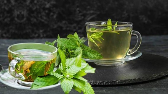 3. Nane Çayı
Nane çayı, Antik Yunan’dan beri şifalı bir içecek olarak kullanılıyor. İçerisindeki mentol, doğal bir kas gevşetici olarak rahim kasılmalarını yatıştırıyor ve krampları hafifletiyor. 2019’da yapılan bir çalışma, mentolün kas spazmlarını azalttığını ve bu nedenle adet sancılarına iyi geldiğini gösteriyor. Ayrıca nane çayı, sindirimi destekleyerek şişkinlik hissini azaltıyor.

Hazırlanışı: 1 çay kaşığı kurutulmuş nane yaprağını sıcak suda 5-10 dakika demleyin. Taze nane yaprakları da kullanılabilir.