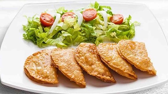 6. Çiğ Börek – Eskişehir
​​​​​​​Eskişehir’in sokak lezzetleri arasında çiğ börek, nam-ı diğer çibörek, tartışmasız bir yıldız. İnce hamurun içine yerleştirilen kıymalı harç, kızgın yağda çıtır bir dış yüzeyle buluşuyor. Soğan, kıyma ve baharatların uyumu, özel pişirme tekniğiyle birleşince ortaya eşsiz bir tat çıkıyor. Odunpazarı’nın tarihi dokusunda veya Sazova Parkı’nda bir çiğ börek molası, Eskişehir gezinizi taçlandırır.