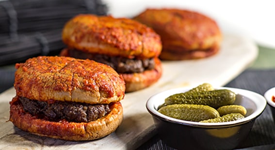 4. Islak Hamburger – İstanbul
​​​​​​​İstanbul’un kaotik ve renkli sokaklarında, lezzet avcılarının favorisi ıslak hamburger! Taksim’den Kadıköy’e, bu minik ama lezzet bombası hamburgerler, özel sosu ve buharda pişirilmiş yumuşacık ekmeğiyle fark yaratıyor. 1970’lerden beri Beyoğlu ve Kadıköy’deki bazı köklü dükkanlarda orijinal tarifine sadık kalınarak hazırlanıyor. Baharatlı köftesi ve sosuyla her ısırıkta ayrı bir tat patlaması yaşatan ıslak hamburger, İstanbul’un sokak lezzetleri arasında tahtını kimseye kaptırmıyor.