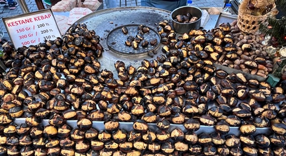 1. Kestane Kebap – Bursa
Bursa’nın tarihi sokaklarında gezintiye çıktığınızda, özellikle kış aylarında havayı saran mis gibi kestane kokusuna dayanmak neredeyse imkansız. Kestane kebap, közde ağır ağır pişerken yaydığı sıcaklık ve aromayla sizi kendine çeker. Uludağ’a kayak yapmaya gittiğinizde ya da Heykel Meydanı’nda dolaşırken bu lezzeti mutlaka denemelisiniz.