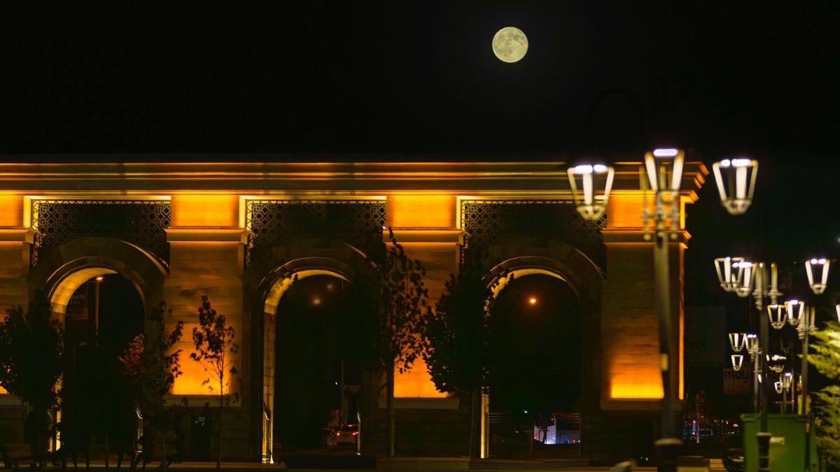 Recep Tayyip Erdoğan Millet Bahçesi’nin kemerleri üzerinde yükselen dolunay, ağaç siluetleriyle etkileyici bir gece atmosferi sunuyor.